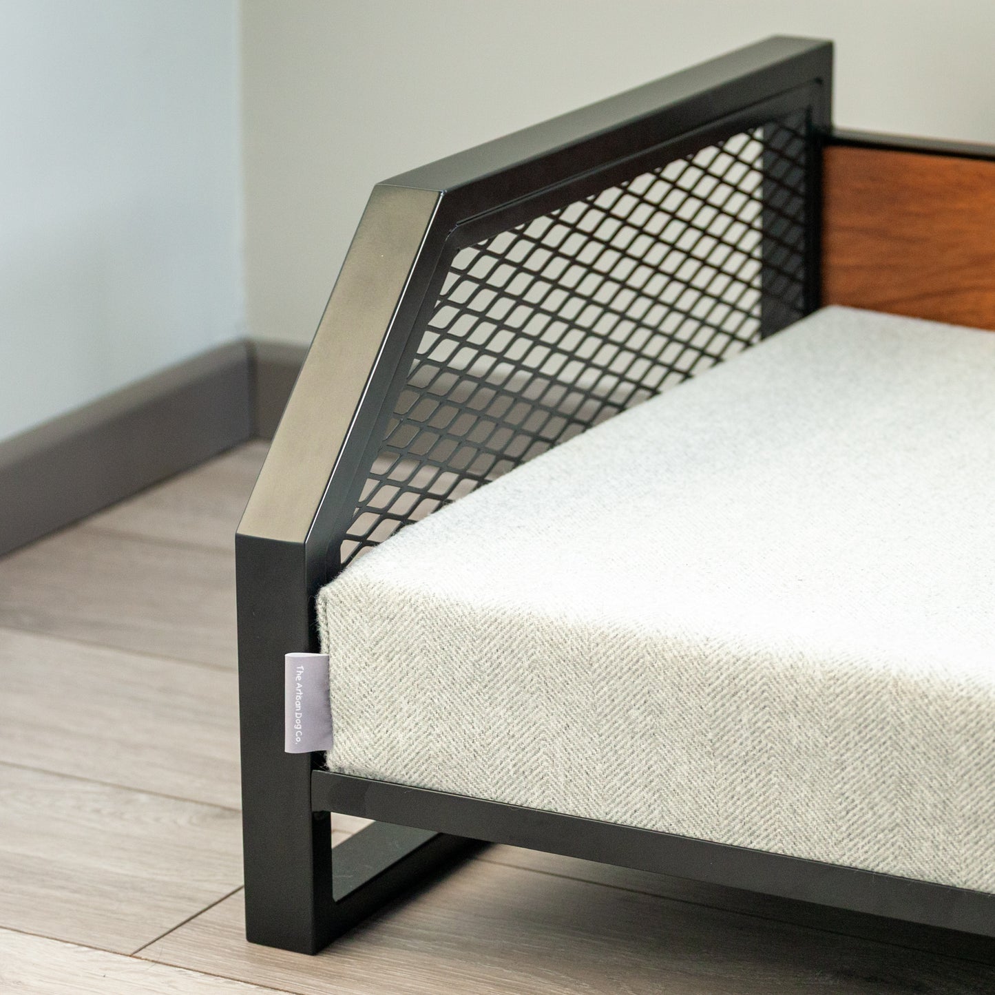 Modern pet bed with a luxury wood backrest raised off the floor to aid comfort and cleanliness.